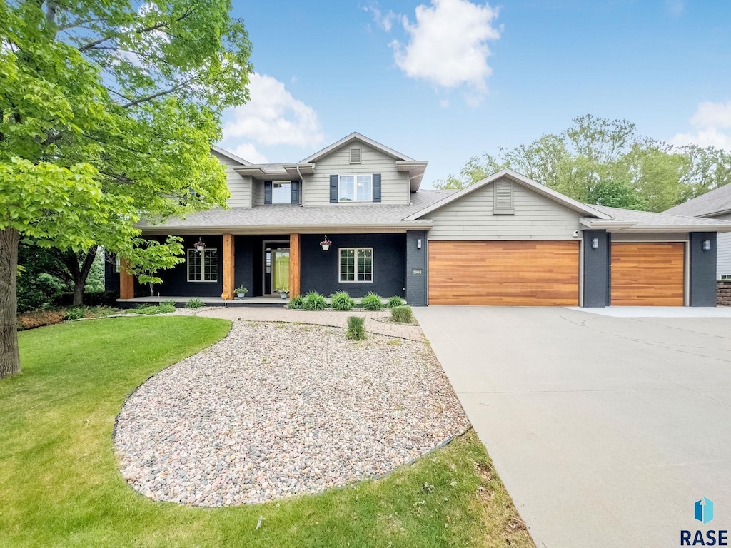 5904 S Deer Park Dr, Sioux Falls, SD 57108 - view of front facade featuring an attached garage, driveway, a front yard, covered porch, and roof with shingles