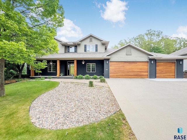 5904 S Deer Park Dr, Sioux Falls, SD 57108 - view of front facade featuring an attached garage, driveway, a front yard, covered porch, and roof with shingles