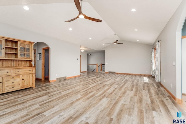 1817 W Ashton Trl, Brandon, SD 57005 - unfurnished living room featuring ceiling fan, arched walkways, vaulted ceiling, light wood finished floors, and baseboards