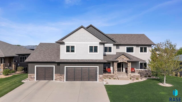 1301 S Hyannis Port Ln, Sioux Falls, SD 57106 - craftsman-style home featuring stone siding, concrete driveway, board and batten siding, a front yard, and roof with shingles