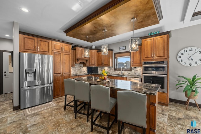1301 S Hyannis Port Ln, Sioux Falls, SD 57106 - kitchen with appliances with stainless steel finishes, a sink, brown cabinetry, tasteful backsplash, and recessed lighting
