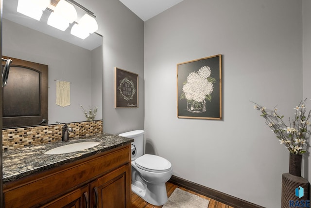 1301 S Hyannis Port Ln, Sioux Falls, SD 57106 - bathroom featuring toilet, wood finished floors, vanity, backsplash, and baseboards