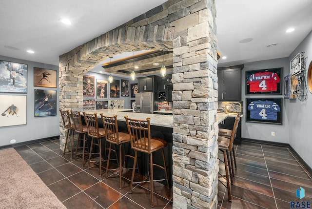1301 S Hyannis Port Ln, Sioux Falls, SD 57106 - indoor wet bar with stainless steel fridge with ice dispenser, recessed lighting, dark tile patterned flooring, decorative light fixtures, and baseboards