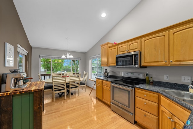 7308 W 53rd St, Sioux Falls, SD 57106 - kitchen with stainless steel appliances, light wood-style floors, a sink, a chandelier, and pendant lighting