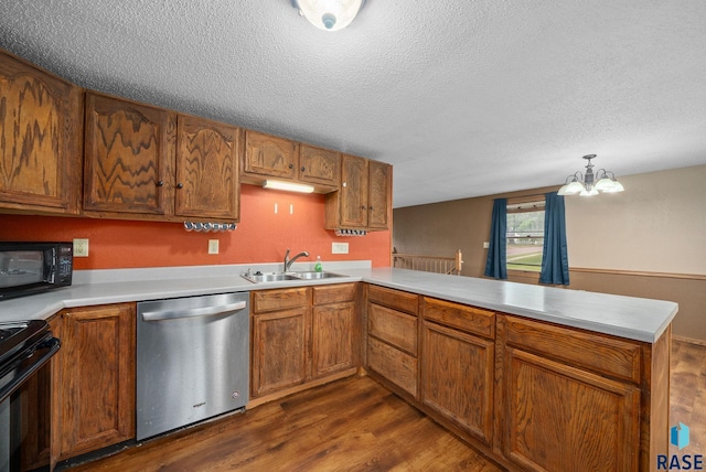 1300 S Point Dr, Sioux Falls, SD 57103 - kitchen with black appliances, a sink, dark wood-type flooring, a peninsula, and a textured ceiling