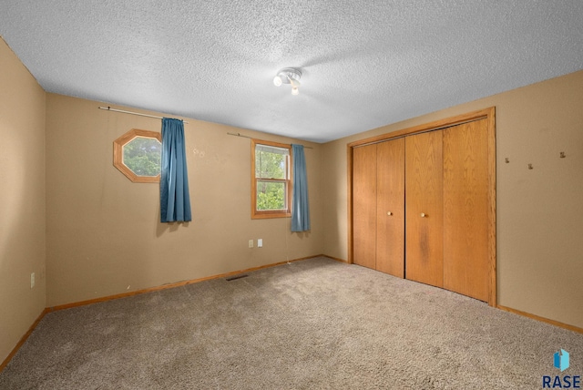 1300 S Point Dr, Sioux Falls, SD 57103 - unfurnished bedroom with carpet floors, a textured ceiling, a closet, and baseboards