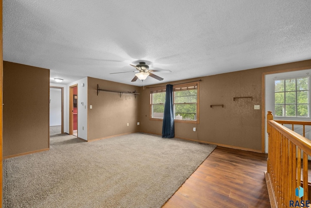 1300 S Point Dr, Sioux Falls, SD 57103 - unfurnished living room featuring a textured ceiling, ceiling fan, wood finished floors, and baseboards