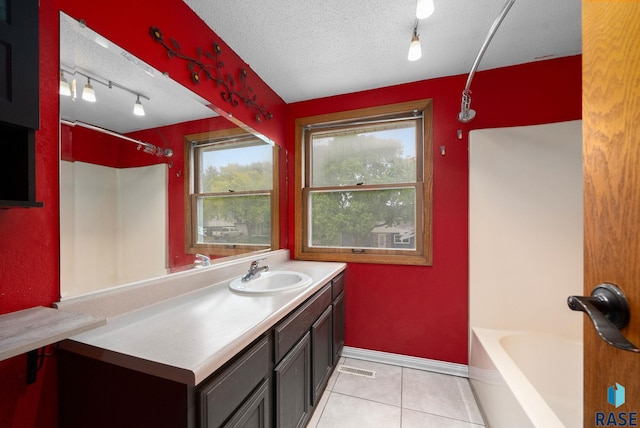 1300 S Point Dr, Sioux Falls, SD 57103 - full bathroom featuring rail lighting, vanity, tile patterned floors, and a textured ceiling