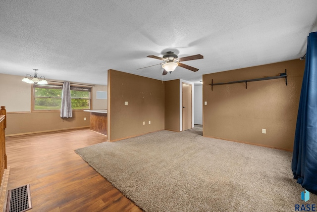 1300 S Point Dr, Sioux Falls, SD 57103 - unfurnished living room featuring ceiling fan, a textured ceiling, a chandelier, wood finished floors, and baseboards