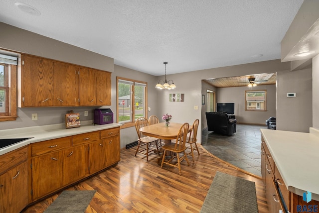 350 W Maple St, Edgerton, MN 56128 - kitchen featuring brown cabinets, a textured ceiling, light countertops, and healthy amount of natural light