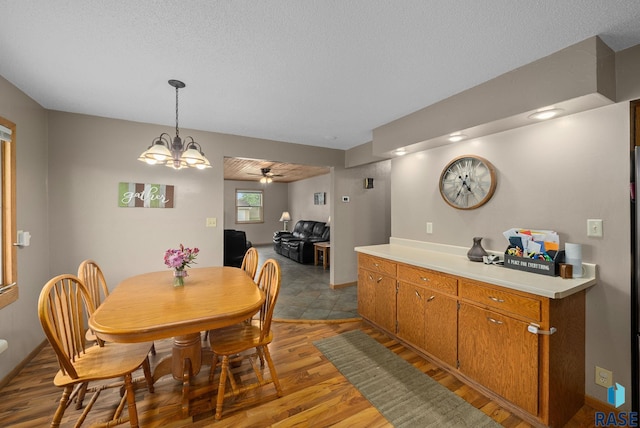 350 W Maple St, Edgerton, MN 56128 - dining area with light wood finished floors, ceiling fan, a chandelier, and a textured ceiling