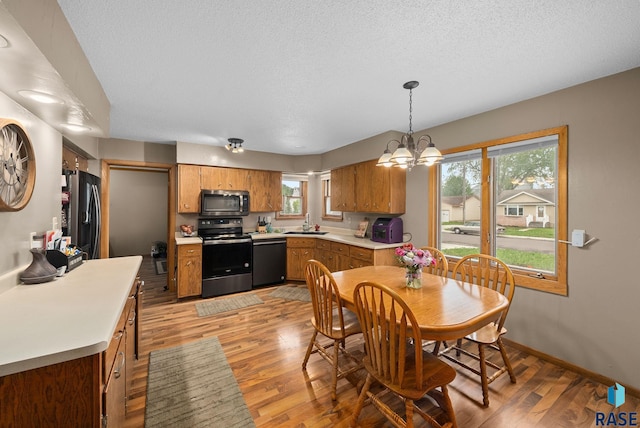 350 W Maple St, Edgerton, MN 56128 - dining area featuring light wood-type flooring, a chandelier, a textured ceiling, and baseboards