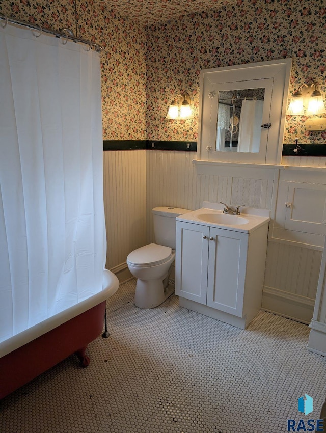 302 E 19th St, Sioux Falls, SD 57105 - bathroom with wallpapered walls, a wainscoted wall, vanity, toilet, and a tub