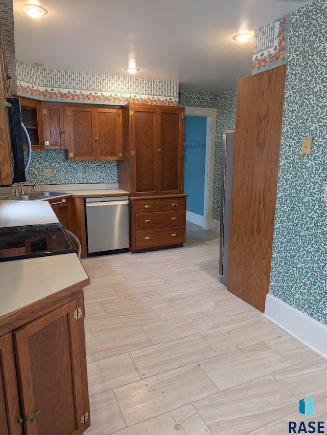 302 E 19th St, Sioux Falls, SD 57105 - kitchen featuring dishwasher, wallpapered walls, a sink, brown cabinets, and electric range