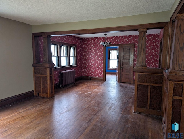 302 E 19th St, Sioux Falls, SD 57105 - empty room featuring radiator heating unit, wallpapered walls, healthy amount of natural light, wood finished floors, and baseboards