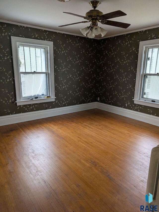 302 E 19th St, Sioux Falls, SD 57105 - spare room featuring wallpapered walls, wood finished floors, plenty of natural light, a ceiling fan, and crown molding