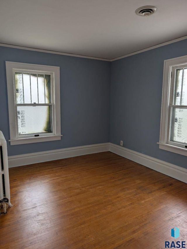 302 E 19th St, Sioux Falls, SD 57105 - empty room with wood finished floors, ornamental molding, baseboards, and radiator heating unit