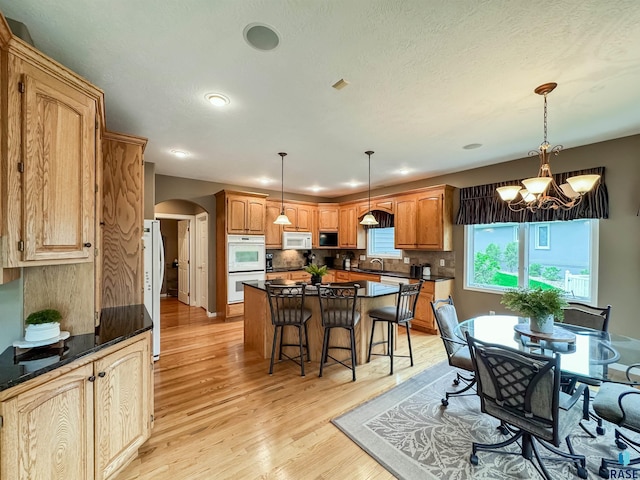 108 W Hazeltine Ln, Sioux Falls, SD 57108 - dining space with arched walkways, light wood-style flooring, a chandelier, and recessed lighting