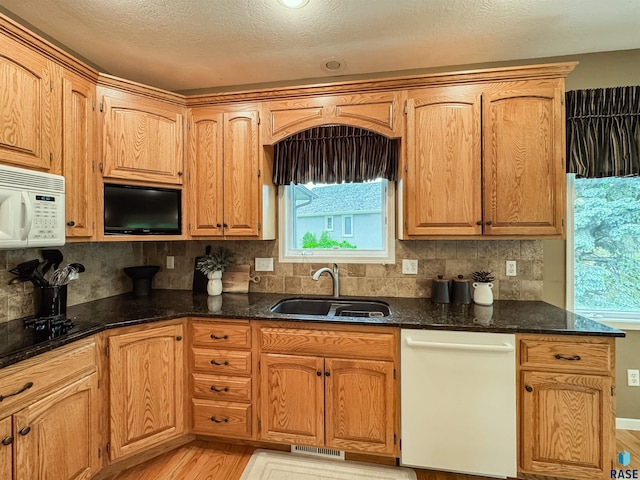 108 W Hazeltine Ln, Sioux Falls, SD 57108 - kitchen with white appliances, a sink, light wood-style floors, dark stone countertops, and backsplash