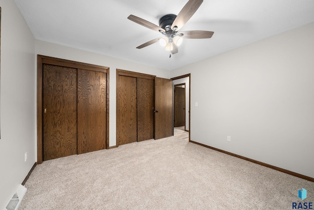 1912 E Sylvan Cir, Brandon, SD 57005 - unfurnished bedroom with light colored carpet, two closets, and baseboards