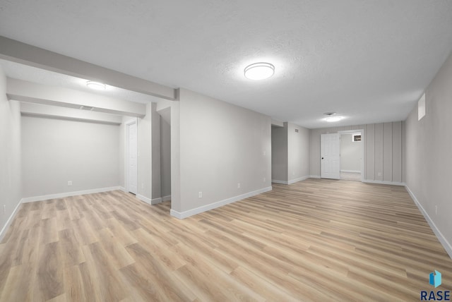 1912 E Sylvan Cir, Brandon, SD 57005 - finished below grade area with light wood-style flooring, baseboards, and a textured ceiling