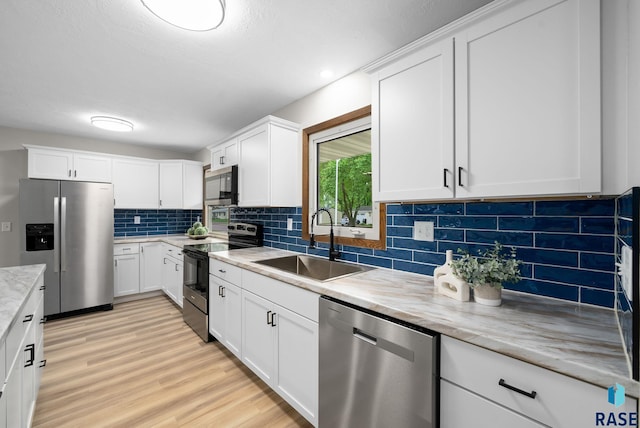 1912 E Sylvan Cir, Brandon, SD 57005 - kitchen with stainless steel appliances, a sink, light wood-style floors, tasteful backsplash, and white cabinets