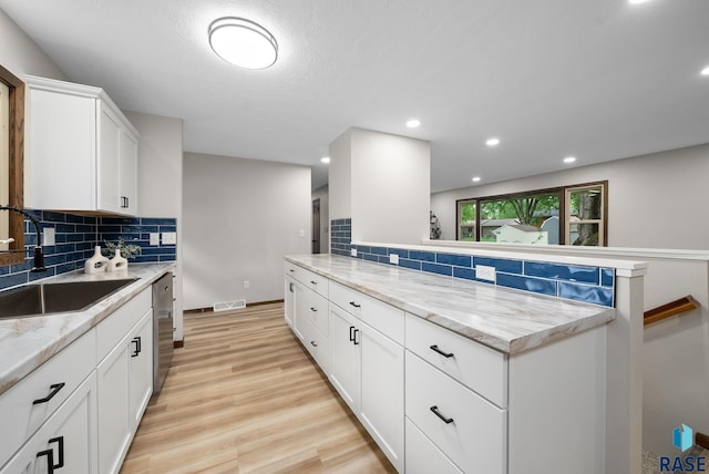 1912 E Sylvan Cir, Brandon, SD 57005 - kitchen featuring a sink, stainless steel dishwasher, decorative backsplash, light wood-style floors, and recessed lighting