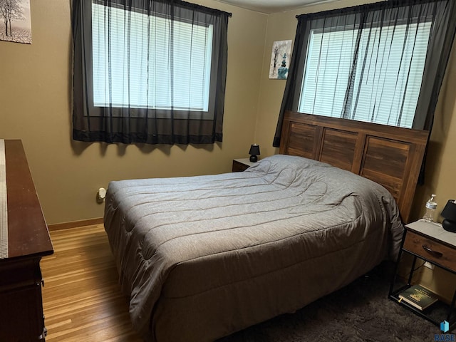 822 S Jessica Ave, Sioux Falls, SD 57103 - bedroom featuring wood finished floors, baseboards, and multiple windows