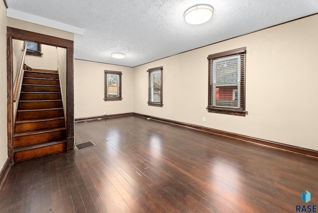 1530 W 10th St, Sioux Falls, SD 57104 - empty room with healthy amount of natural light, dark wood-style floors, a textured ceiling, and baseboards