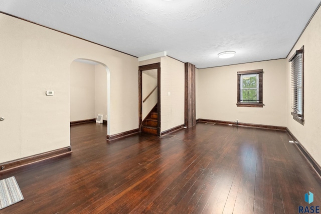 1530 W 10th St, Sioux Falls, SD 57104 - unfurnished room with stairway, arched walkways, hardwood / wood-style flooring, baseboards, and a textured ceiling