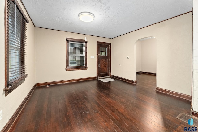 1530 W 10th St, Sioux Falls, SD 57104 - empty room featuring arched walkways, wood-type flooring, baseboards, and a textured ceiling