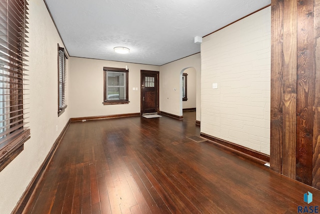 1530 W 10th St, Sioux Falls, SD 57104 - empty room featuring arched walkways, wood-type flooring, baseboards, and a textured ceiling