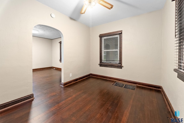 1530 W 10th St, Sioux Falls, SD 57104 - empty room featuring arched walkways, wood finished floors, ceiling fan, and baseboards