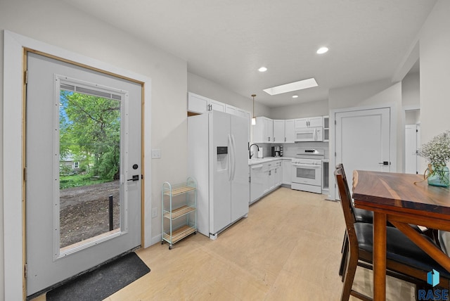 1709 S Duluth Ave, Sioux Falls, SD 57105 - kitchen featuring white appliances, a skylight, light countertops, white cabinets, and recessed lighting