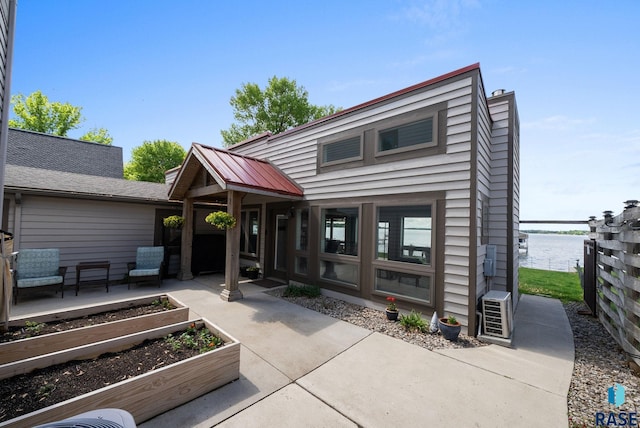 6604 Peninsula Pt, Wentworth, SD 57075 - view of front of home with a vegetable garden, a patio area, a water view, and a chimney