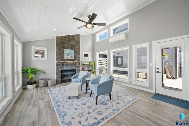 6604 Peninsula Pt, Wentworth, SD 57075 - living room featuring a wall mounted air conditioner, lofted ceiling, a large fireplace, a ceiling fan, and wood ceiling