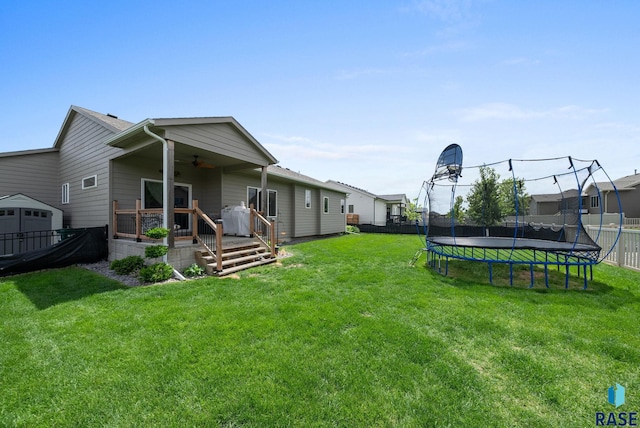 5205 S Eastwind Ave, Sioux Falls, SD 57108 - view of yard with a ceiling fan, a trampoline, and a wooden deck