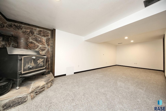 121 S Elm St, Lennox, SD 57039 - unfurnished living room featuring a wood stove, carpet floors, baseboards, and recessed lighting