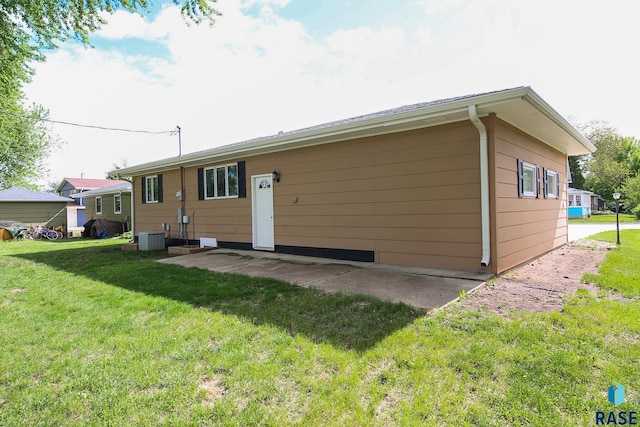 121 S Elm St, Lennox, SD 57039 - rear view of house featuring a lawn and central AC