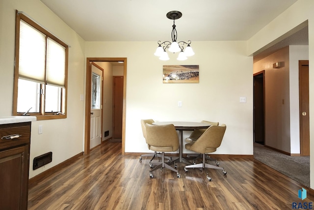121 S Elm St, Lennox, SD 57039 - dining area featuring dark wood-style flooring, a chandelier, and baseboards