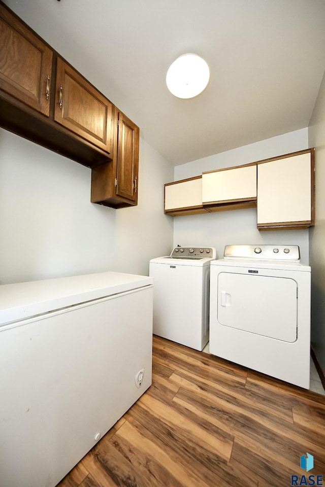 121 S Elm St, Lennox, SD 57039 - laundry area with washer and clothes dryer, cabinet space, and wood finished floors