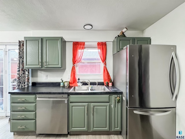 101 N Pipestone St Unit 3, Brandon, SD 57005 - kitchen with stainless steel appliances, green cabinets, a sink, dark countertops, and a textured ceiling