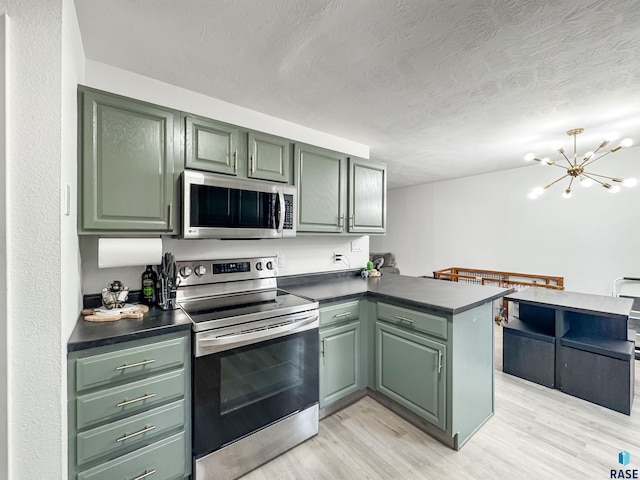 101 N Pipestone St Unit 3, Brandon, SD 57005 - kitchen with stainless steel appliances, a peninsula, dark countertops, green cabinets, and a textured ceiling