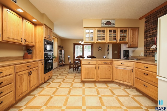 48224 266th St, Brandon, SD 57005 - kitchen with black appliances, a peninsula, glass insert cabinets, a textured ceiling, and light countertops