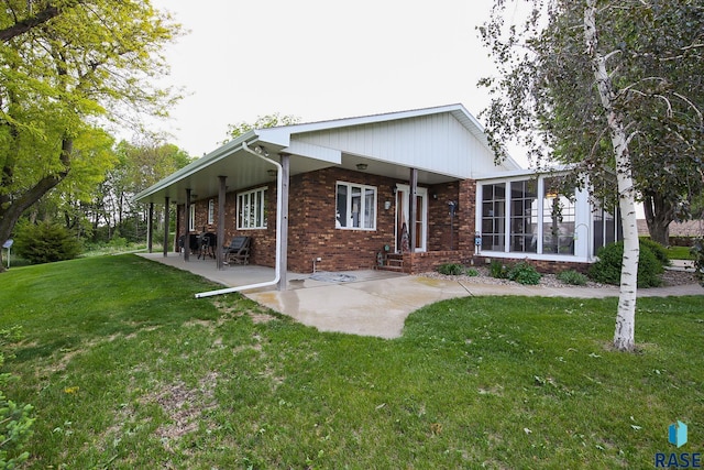 48224 266th St, Brandon, SD 57005 - view of front of house with brick siding, a front lawn, and a patio