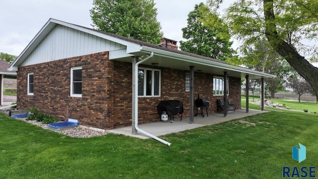 48224 266th St, Brandon, SD 57005 - back of property featuring a yard, brick siding, a patio, and a chimney