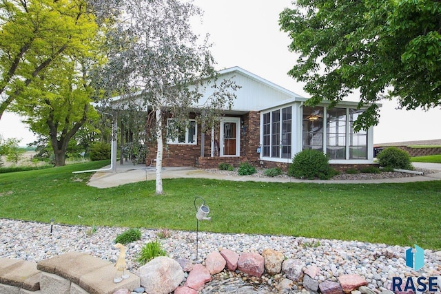 48224 266th St, Brandon, SD 57005 - view of front of home featuring a front yard, a sunroom, and brick siding