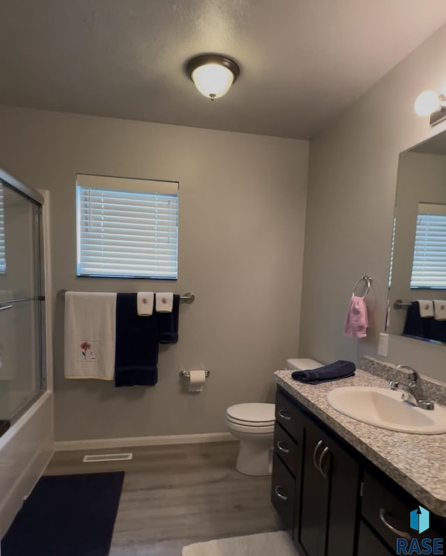 203 Cherry Ln, Chamberlain, SD 57325 - bathroom with wood finished floors, vanity, toilet, and baseboards