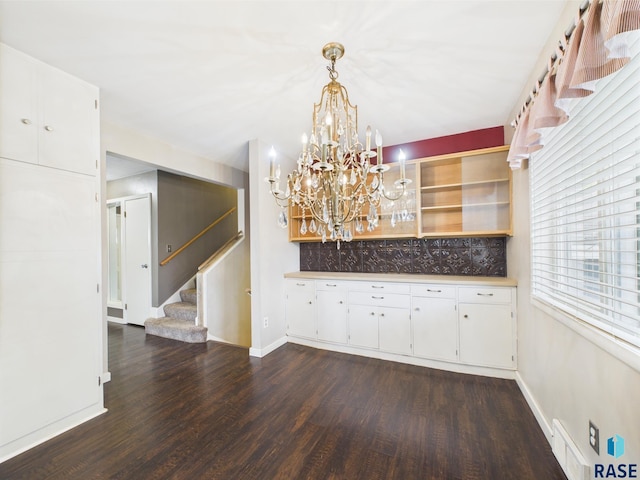 105 S Elm St, Lennox, SD 57039 - unfurnished dining area featuring stairway, dark wood-type flooring, baseboards, and a chandelier