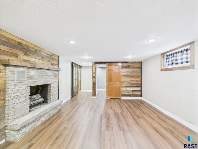 105 S Elm St, Lennox, SD 57039 - unfurnished living room with light wood-style flooring, baseboards, a stone fireplace, and recessed lighting